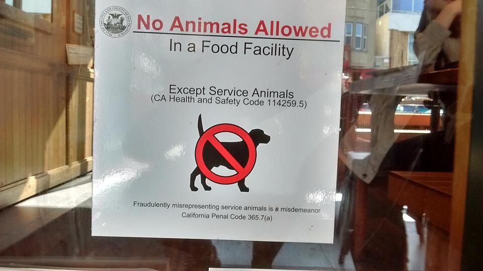 California law prohibits dogs in restaurants und grocery stores.