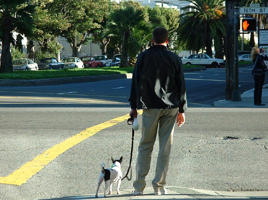 Hundebesitzer in San Francisco. Der Herr hält ein Sackerl mit dem Hundekacki in der linken Hand.