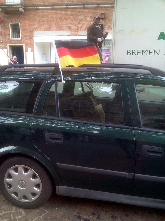Die fußballbegeisterten Deutschen mit ihren Fahnen am Auto.